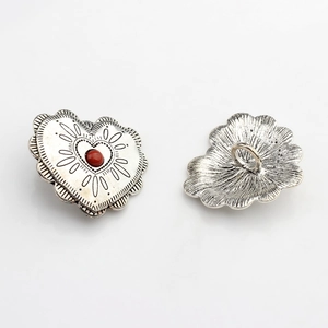 Detailed view of vintage silver heart alloy buttons with red stone and lace edges