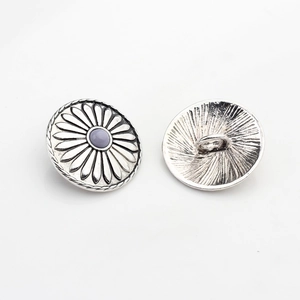 Detail of vintage silver sunflower alloy button with floral engraving and center bead