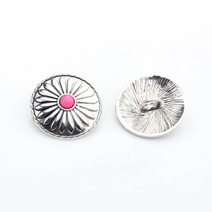 Macro detail of antique silver sunflower metal buttons with pink beads showing both sides