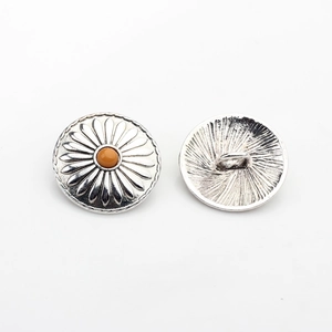 Macro detail of antique silver sunflower buttons with orange resin center for DIY crafts