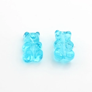Macro shot of two transparent light blue resin gummy bear beads for DIY jewelry making