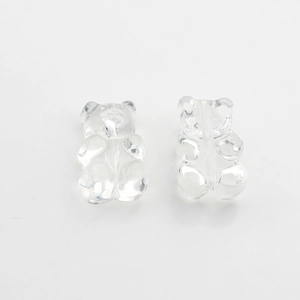 Macro shot of two transparent resin gummy bear beads with center holes for DIY jewelry