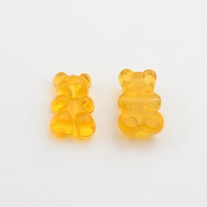 Macro detail of cute yellow candy-colored resin bear charms for DIY jewelry making