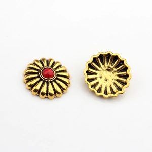 Makroaufnahme von Vintage-Gänseblümchen-Anhängern aus Goldlegierung mit roten Harzperlen
