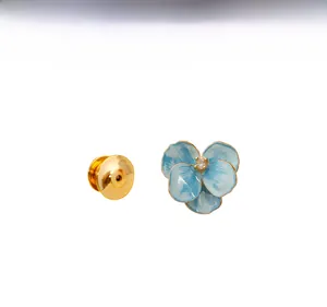 Detailed macro view of blue enamel iris brooch petals and metallic butterfly clasp pin