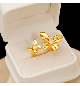 Gros plan d'une bague papillon dorée avec zircones dans un coffret en velours blanc