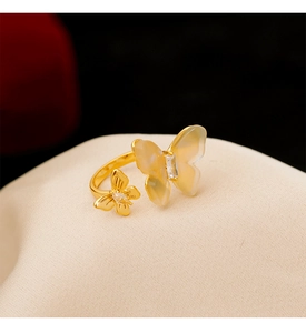 Vue macro détaillée d'une bague double papillon dorée avec résine translucide et zircon