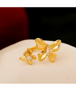 Détail macro d'une bague double papillon dorée avec incrustation de zircon brillant
