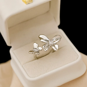 Bague ouverte papillon argentée avec zircons brillants dans un coffret à bijoux