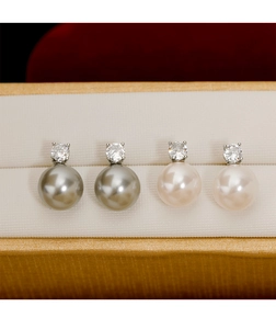 Détail des boucles d'oreilles en perles blanches et argentées avec cristaux de luxe