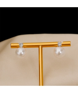 Détails macro de boucles d'oreilles perles classiques avec zircon sur support doré