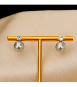 Macro de boucles d'oreilles perles grises élégantes avec zircons sur présentoir doré