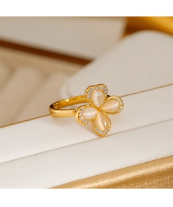 Detail of opal four-leaf clover ring with gold plating and sparkling zircon accents