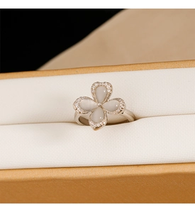 Macro shot of silver four-leaf clover ring with white stone and pave zircons on band