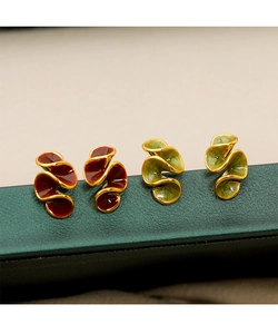 Detail of red and green enamel wave earrings with gold edges on green jewelry box