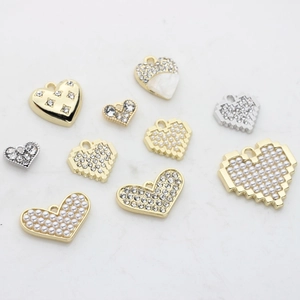 Pendentifs cœur variés avec perles et strass sur marbre pour la création de bijoux DIY