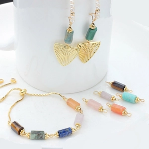 Detail of 14K gold-plated copper earrings and bracelets with colorful natural stone beads