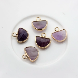 Detailansicht der halbkreisförmigen lila Amethyst-Anhänger mit Goldrand für DIY-Schmuck