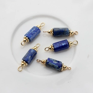 Detailed macro view of 5 natural lapis lazuli stone cylinder pendants with gold connectors