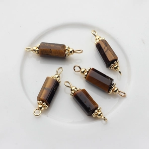 Macro shot of 5 tiger eye stone pendants with 14K gold plated caps and hanging loops
