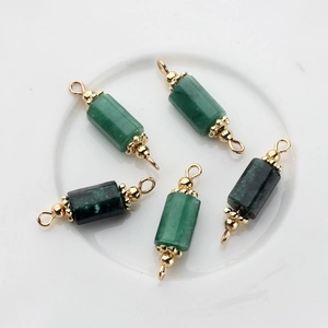 Macro view of five green natural stone cylinder pendants with gold plated end caps