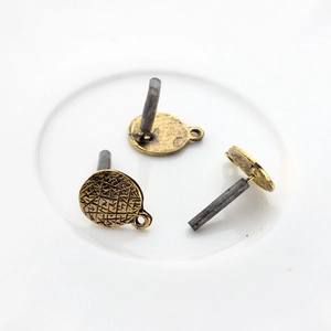 Close-up of vintage alloy earring posts with textured surface for DIY jewelry making