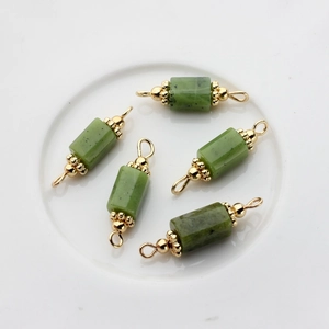 Detailed view of green natural jadeite cylindrical charms with 14K gold-plated connectors