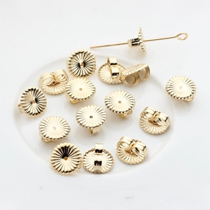 Macro detail of 14K gold plated flower earring backs and S925 engraved jewelry components