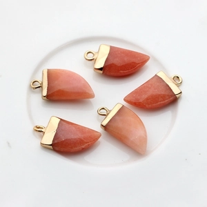 Detailweergave van vijf oranje-roze natuurstenen hangers met vergulde metalen sluitringen
