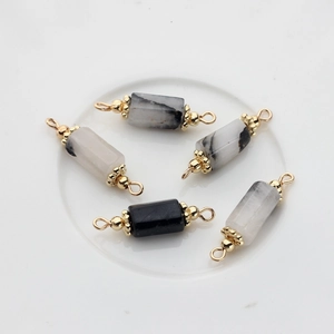 Detail of cylindrical natural stone charms with 14K gold plated double loop connectors
