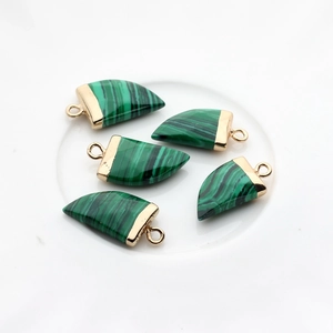 Detailopname van vijf malachiet hoornhangers met gouden kapjes voor DIY-sieraden