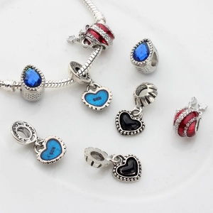 Bracelet chaîne serpent argentée avec pendentif cœur bleu et breloques célestes sur fond blanc