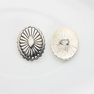 Macro detail of vintage silver oval flower button with shank back for jewelry DIY
