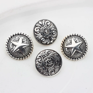 Set of four vintage silver alloy buttons with star and floral relief patterns on white