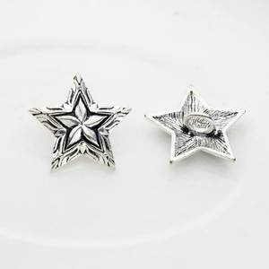 Detailed view of vintage silver star metal button with intricate engraved star patterns