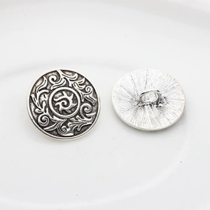 Macro detail of antique silver round metal buttons with vintage floral sunburst engravings