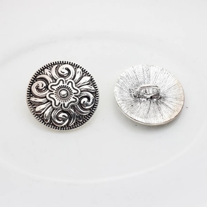 Detail of vintage silver star buttons with floral relief and sewing shank on back