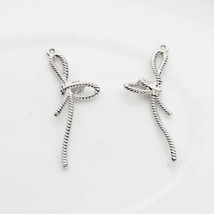 Détail de pendentifs nœuds argentés avec texture tressée pour création de bijoux DIY