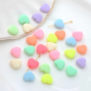 Gekleurde macaron hart acryl kralen voor DIY sieraden maken op een wit keramisch bord