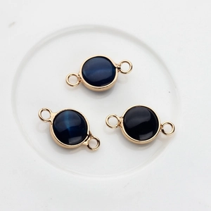 Dettaglio di tre connettori in pietra blu con bordo dorato per collane e bracciali fai-da-te