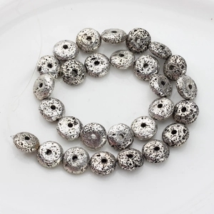 Macro detail of silver plated round lava stone beads with porous texture for DIY jewelry