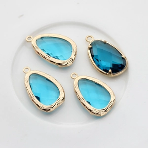 Detail of 4 teardrop-shaped blue glass charms with 14K gold-filled edges for jewelry DIY
