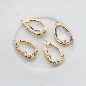 Macro view of four 14K gold-plated teardrop pendants with faceted glass for DIY jewelry