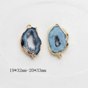 Macro detail of blue geode agate pendants with gold plating and dual connectors