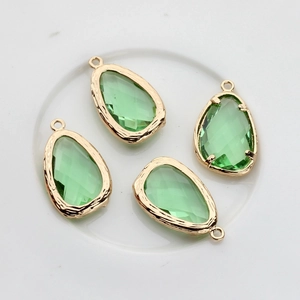 Detail of four light green faceted teardrop pendants with 14K gold plated edging for DIY