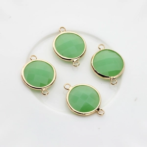 Close-up of four 16mm light green faceted crystal charms with gold double-loop connectors