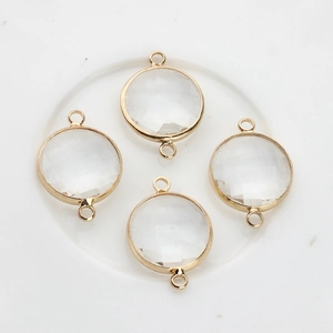 Macro view of four 16mm round faceted crystal pendants with gold plated metal rims
