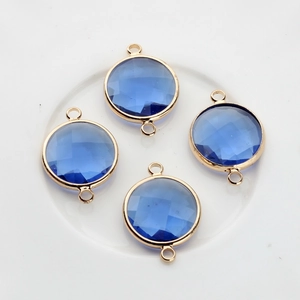 Macro view of four 16mm round blue faceted crystal pendants with gold plated frames