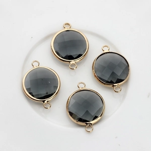 Macro detail of 16mm black faceted crystal connectors in golden copper frames