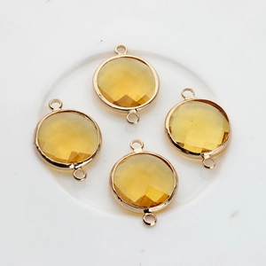 Close-up of 16mm yellow faceted crystal pendants with double-hole gold-plated frames